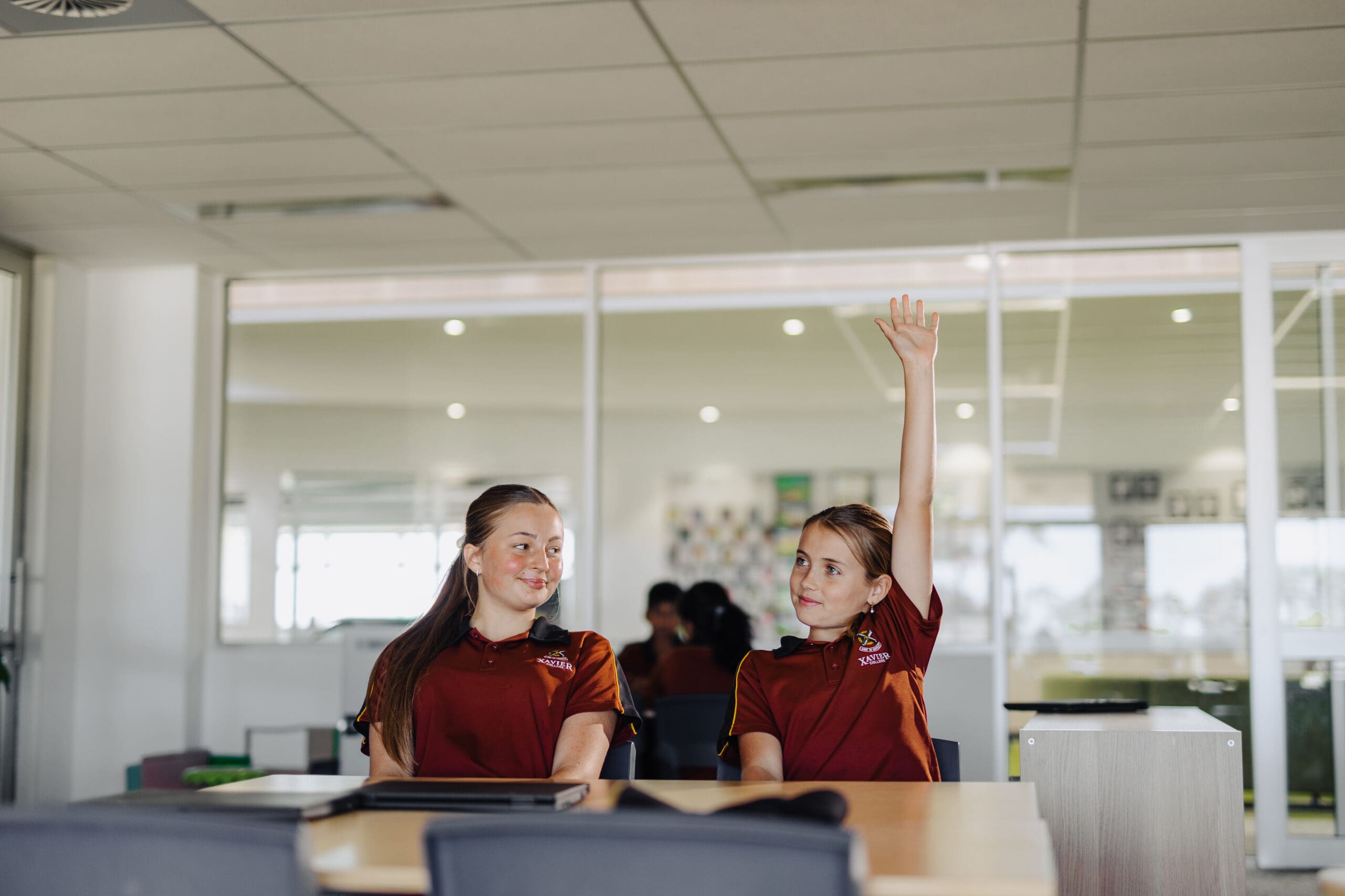 A student raising their hand to ask a question. 