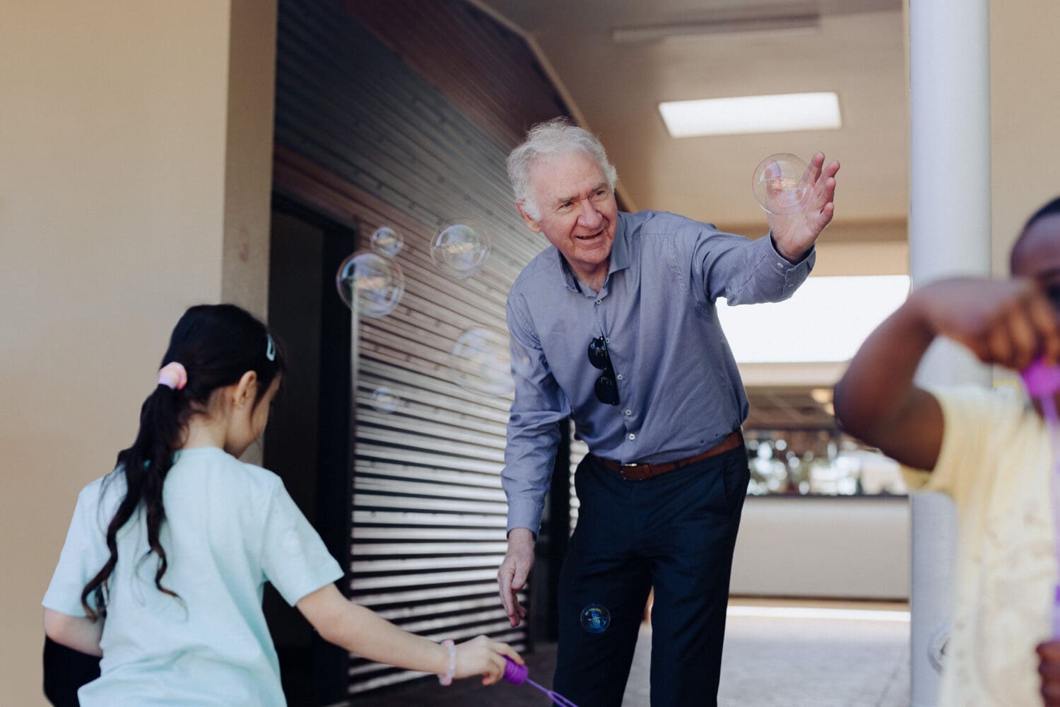 Principal Mark Flaherty engaging student with bubbles