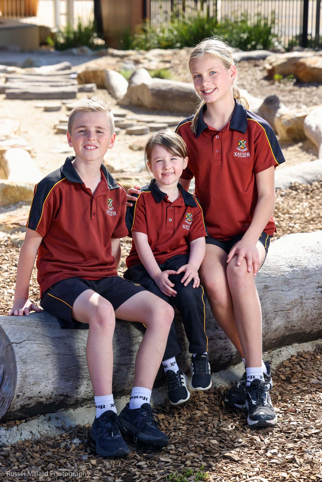 Three students of varying ages modelling the Sport/PE uniform.