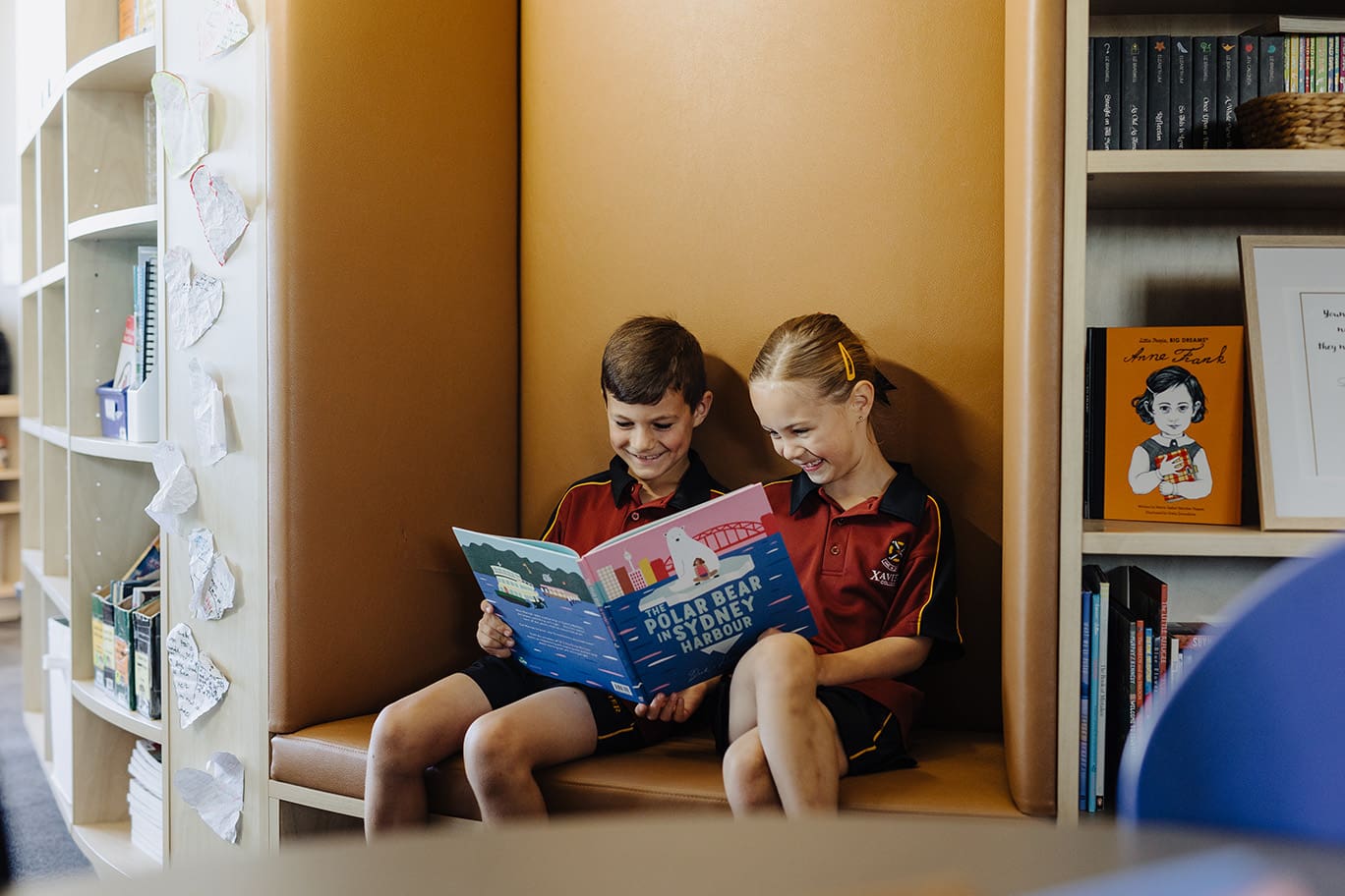 Primary students reading a book together.