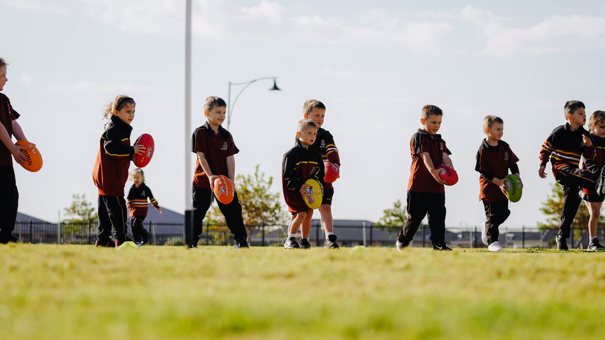 Early years student learning to kick a football. 