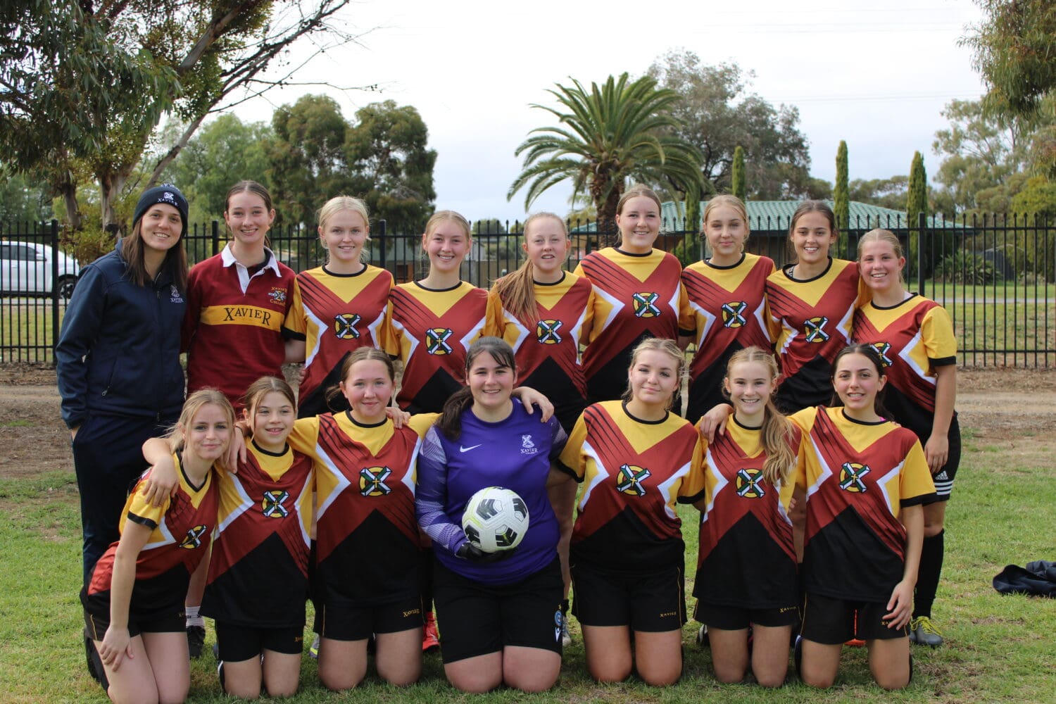 A team photo of the girl's soccer team at the St Columba Sporting Exchnge, standing in two rows dressed in their Xavier College soccer uniforms.