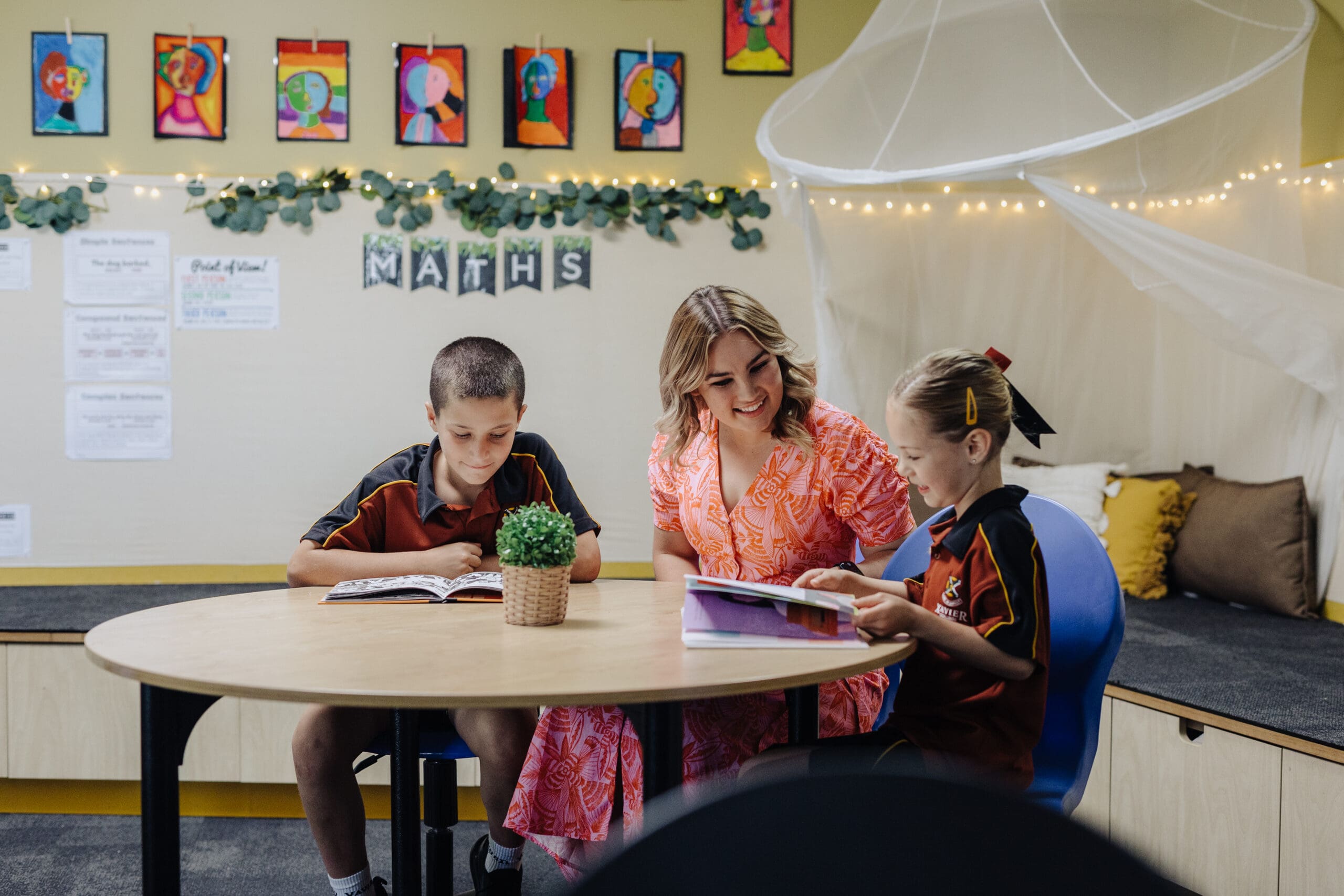 Evanston Campus teacher guiding students through reading a book. 