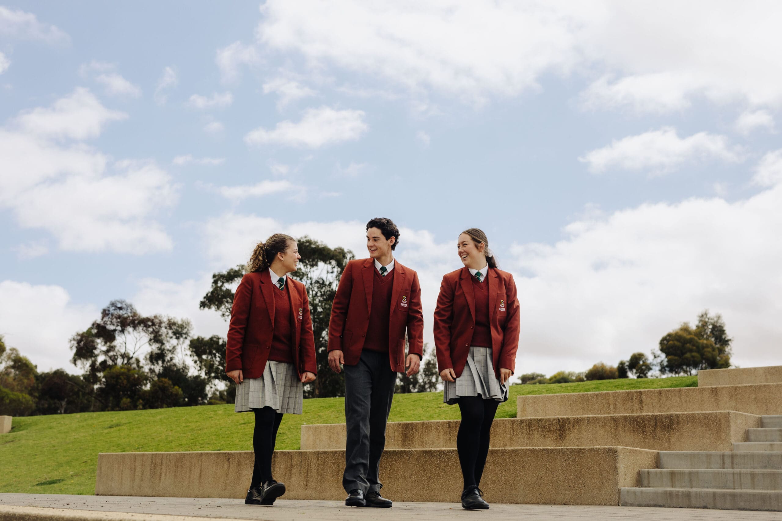 Senior students walking and smiling while discussing their studies. 