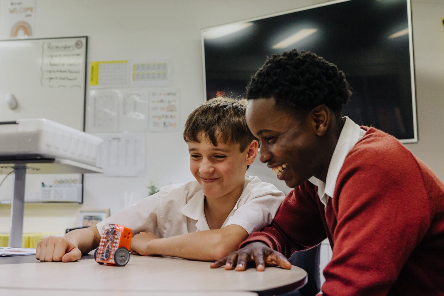 Year 7 to Year 9 students working on a small robotic car in a science classroom