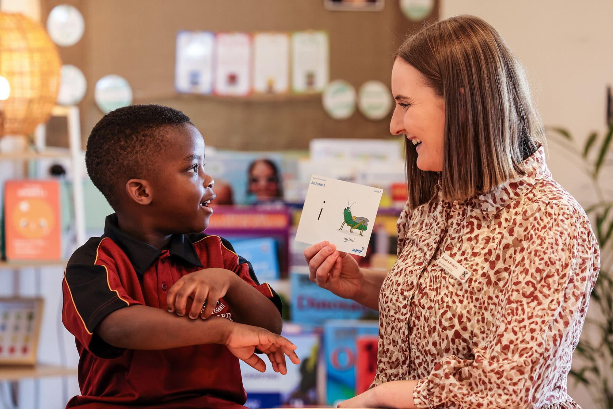 A teacher guiding a student through the alphabet.